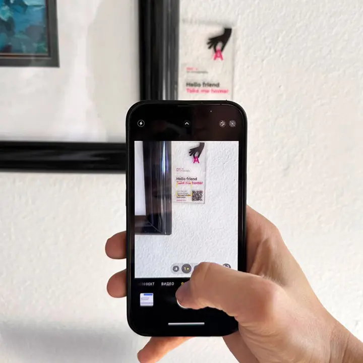 Visitor scanning a QR code beside a displayed artwork